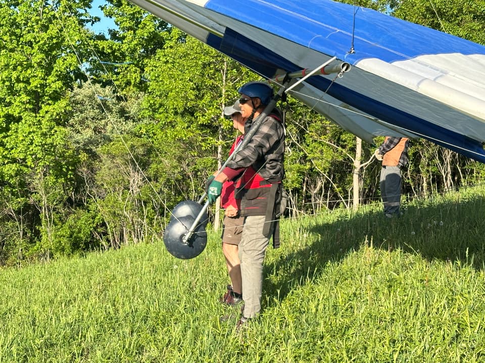 A wire crew helping a pilot prepare to launch